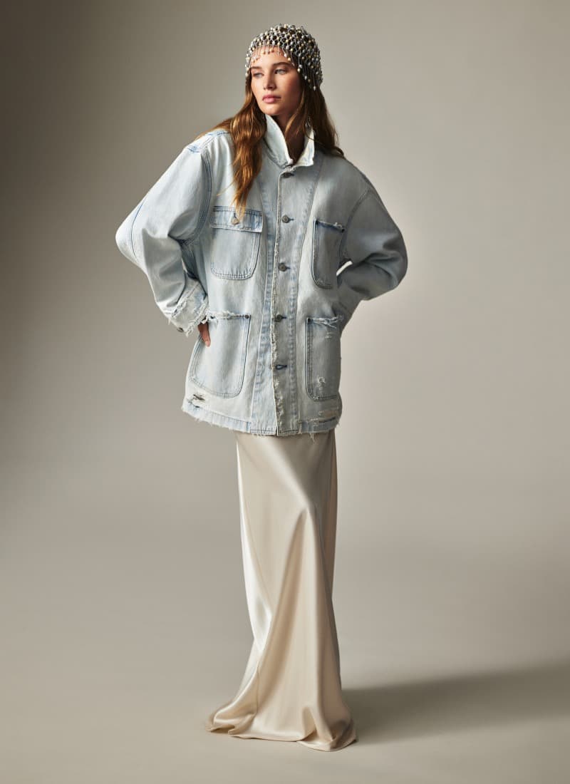 Woman wears blue cable-knit zip-up hoodie.